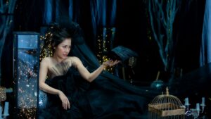 Artistic studio shot of a stylish woman in a black dress with creative lighting.
