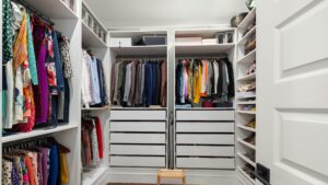 A neatly arranged walk-in closet showcasing a colorful variety of clothes and shoes.